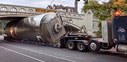 A bright tank being transported on a truck